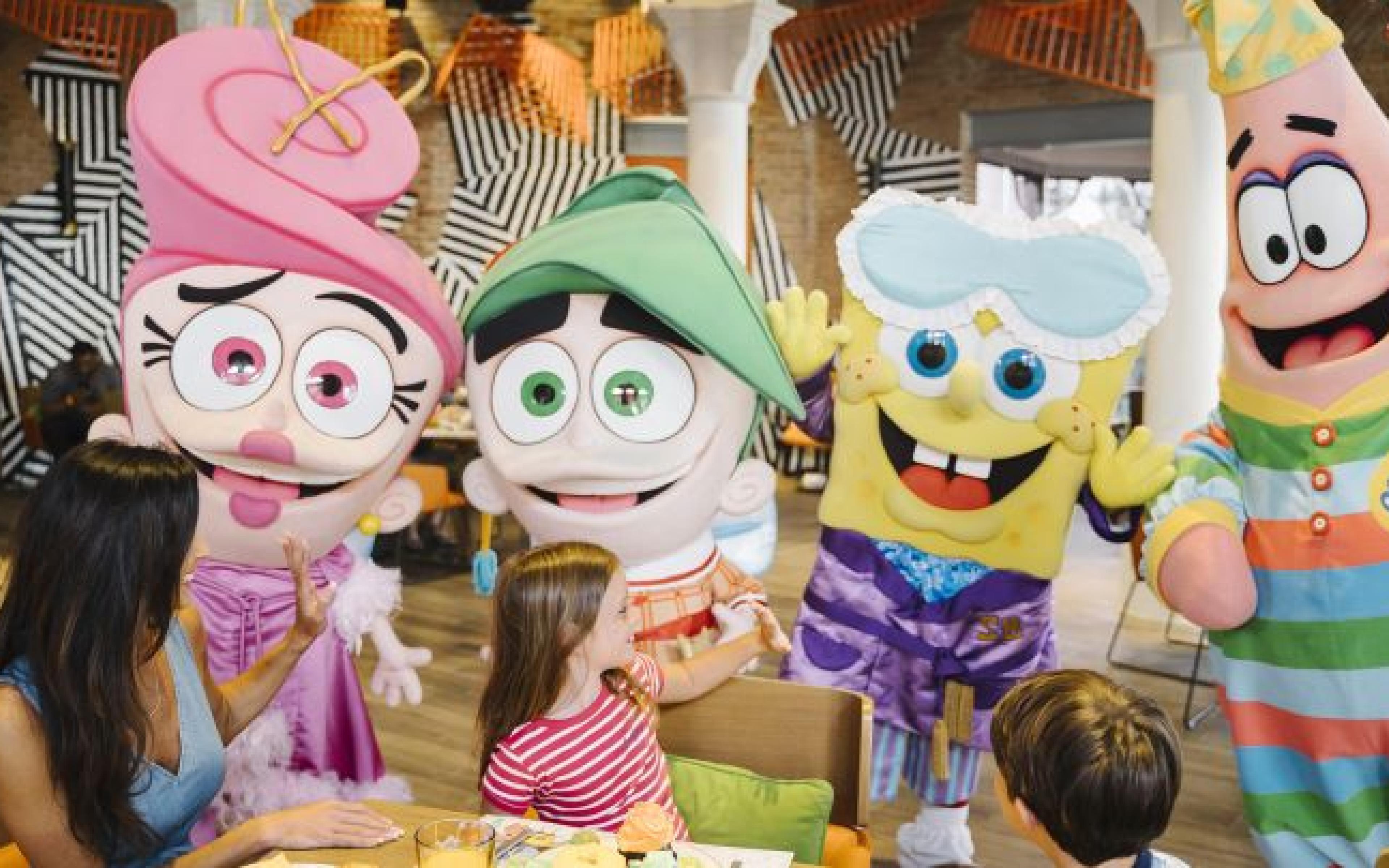 Nickelodeon characters greeting children at a table