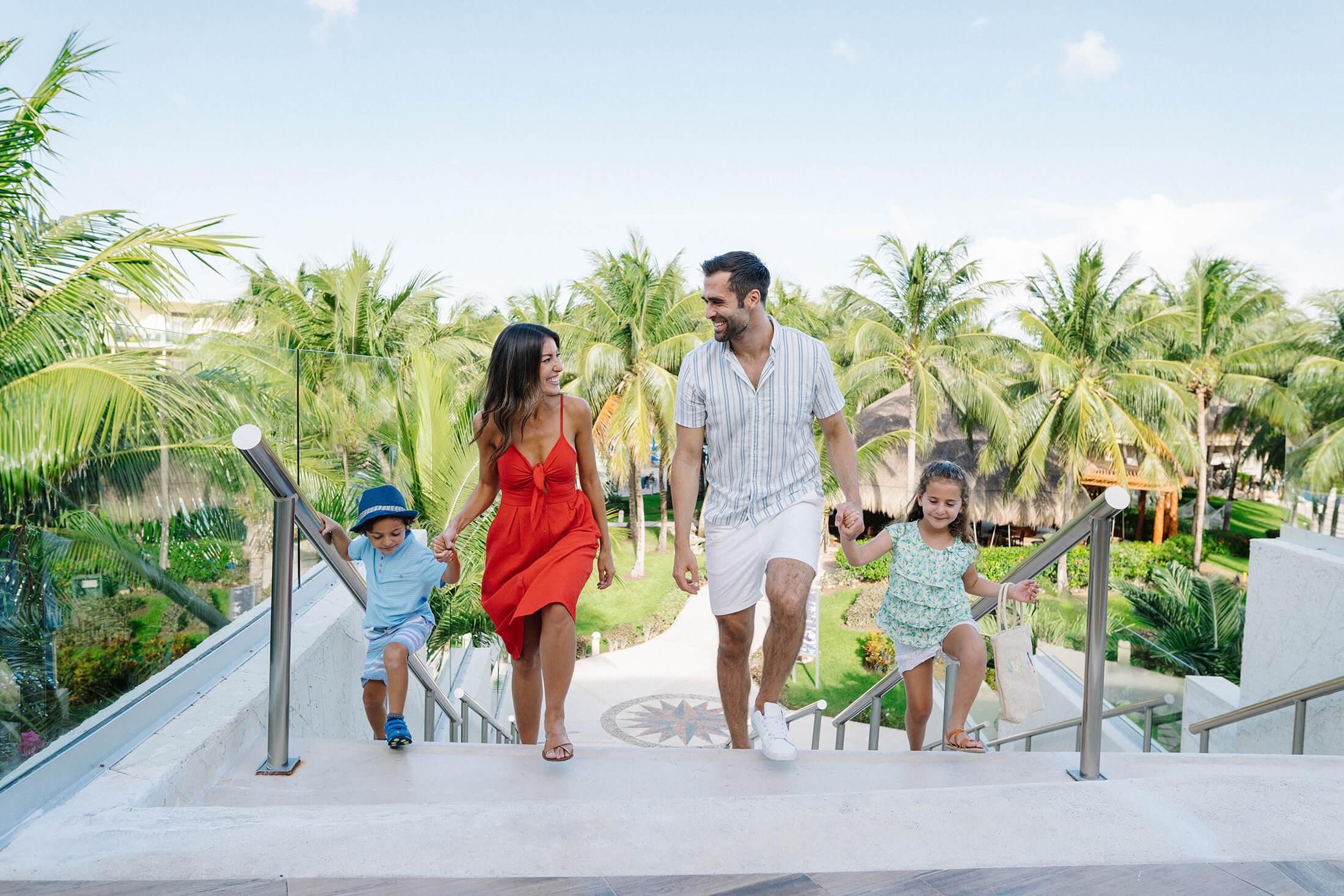 A family walks through the garden terrace at Azul Beach Riviera Cancun