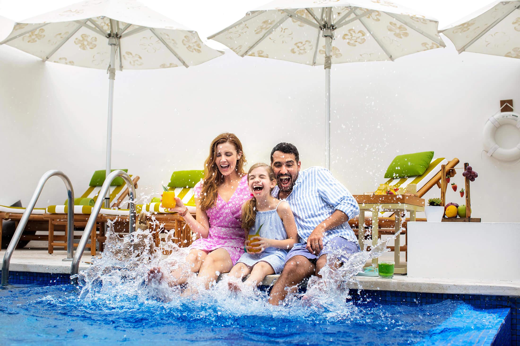 A family splashes in the pool at the pineapple suite