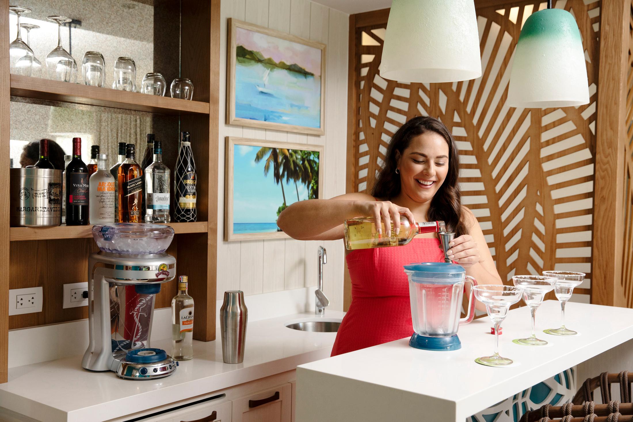 A woman mixes a cocktail in a blender