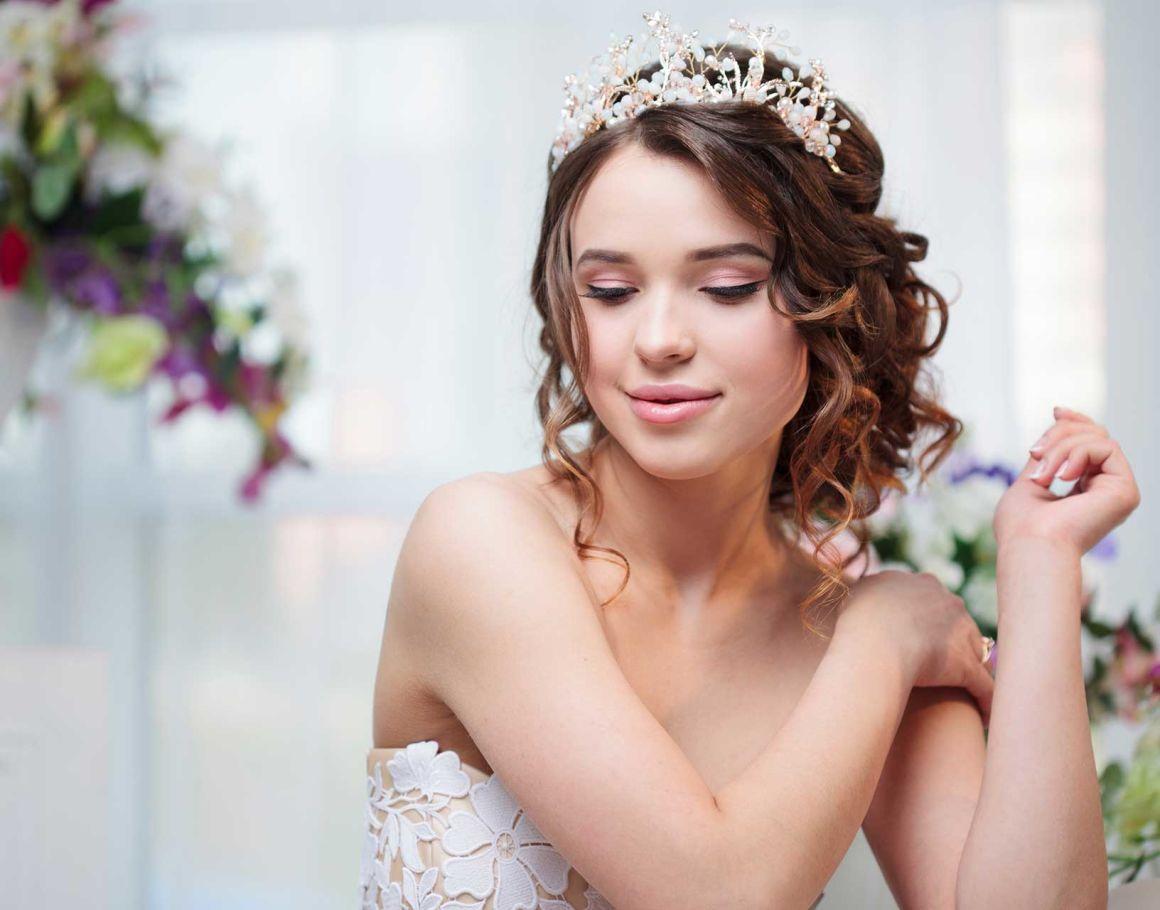 A teen in a white dress and a tiara celebrates her sweet sixteen birthday