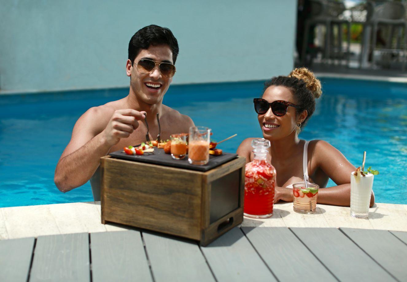 A couple in a pool enjoying food