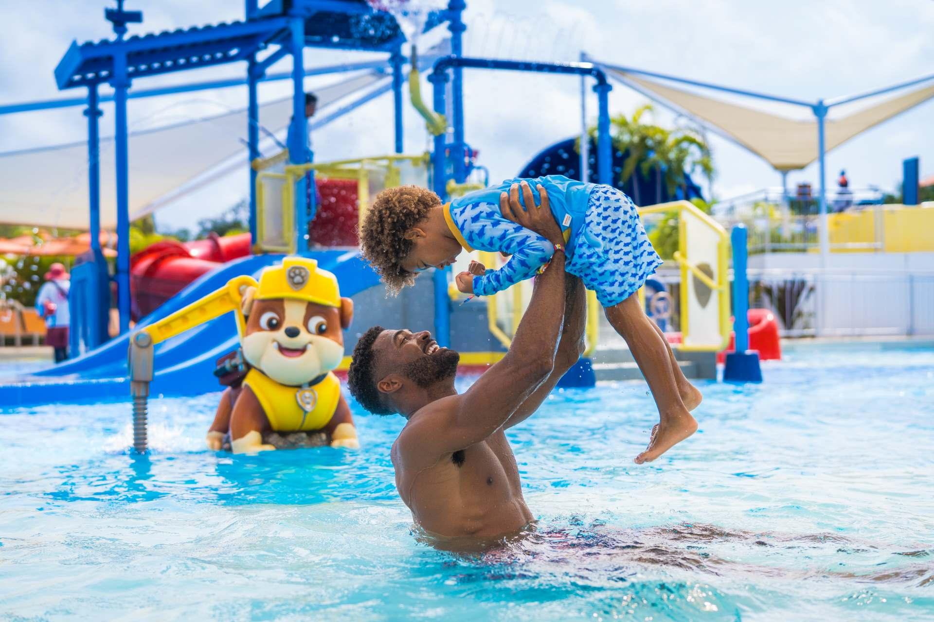 dad and son playing on water