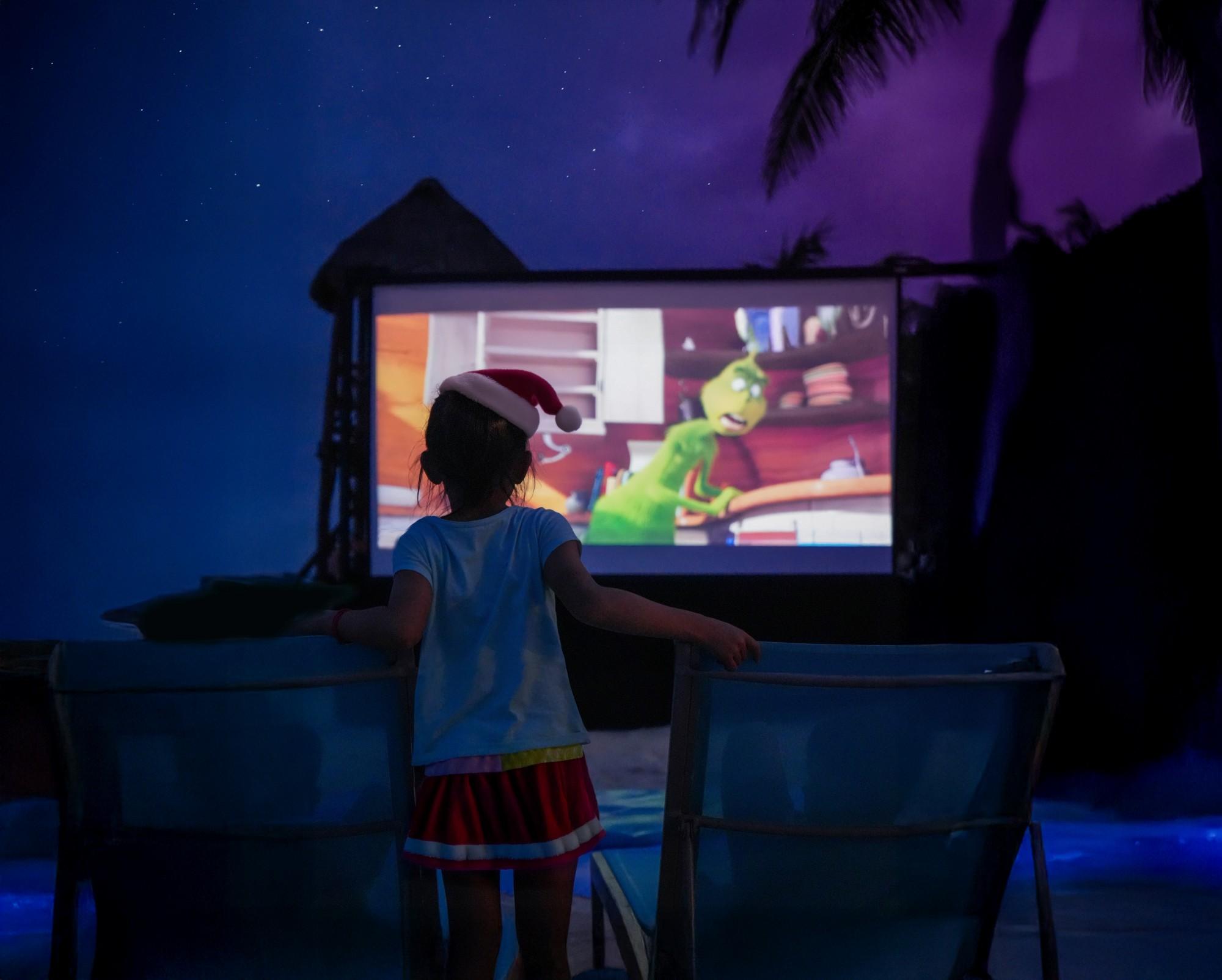 girl watching movies on the beach