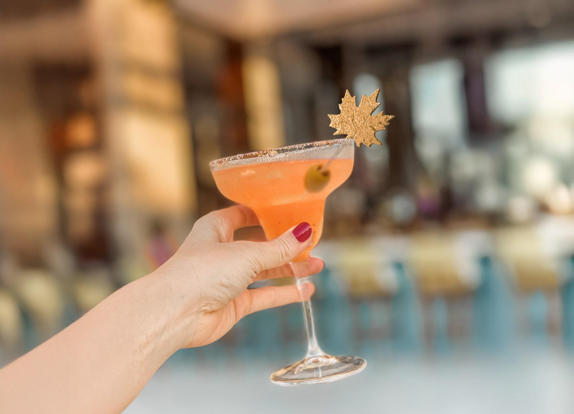 a drink with a festive decoration being held in one hand