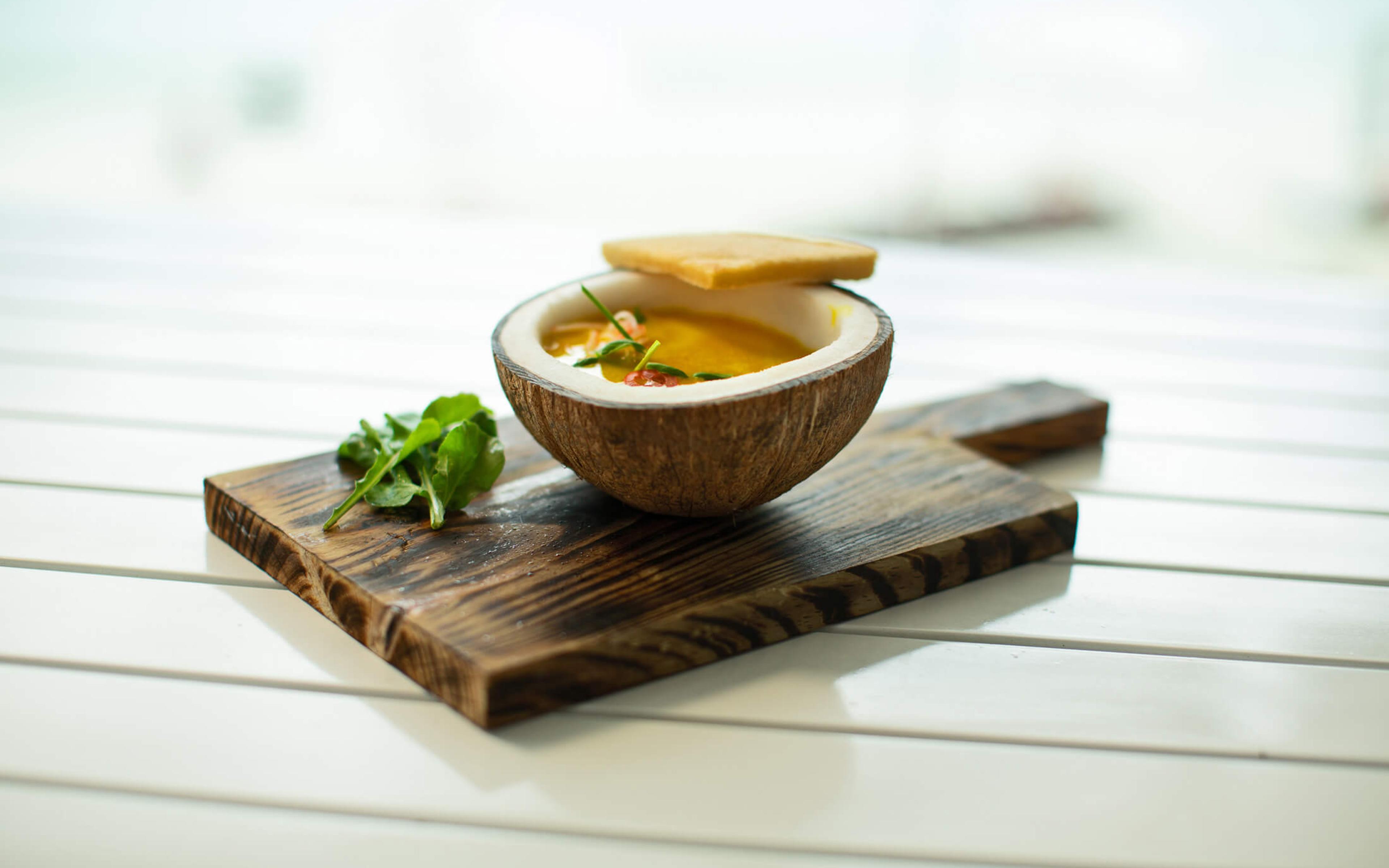 An elegant bowl of soup served in a coconut