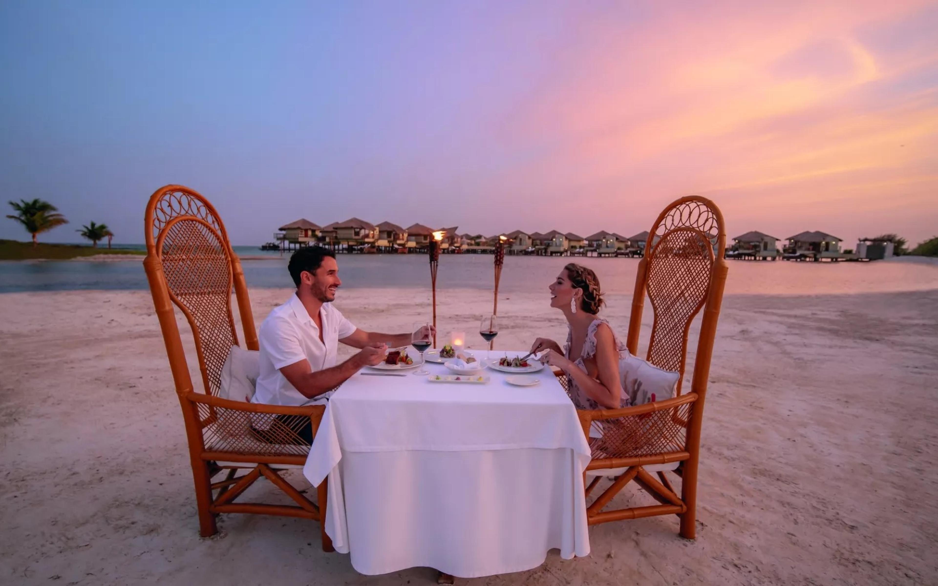 Couple having dinner on a beach table