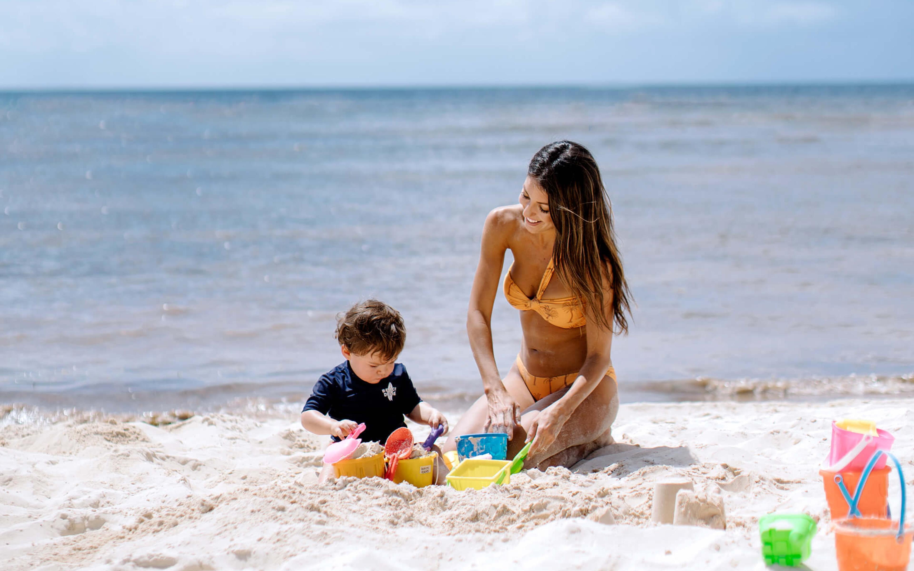 child and mother on beach playing